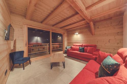 a living room with a red couch and a table at Chalet La Rocca in La Chapelle-dʼAbondance