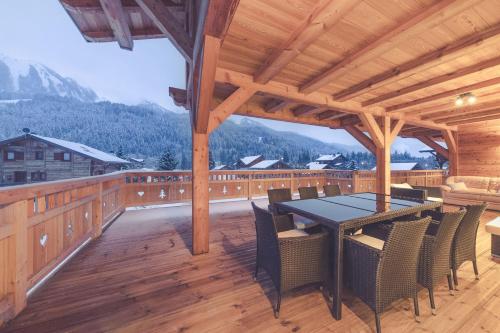a patio with a table and chairs on a deck at Chalet La Rocca in La Chapelle-dʼAbondance