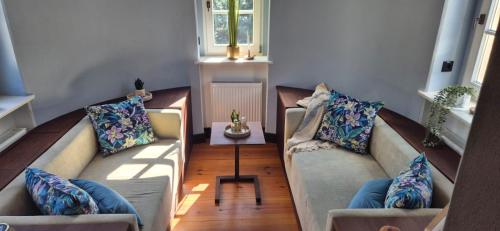 a living room with two couches and a table at Schlosshotel Hohenbocka in Hohenbocka