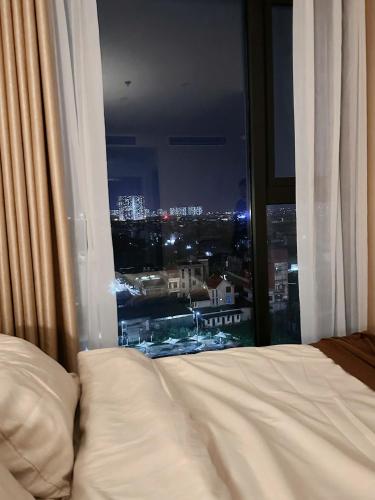 a bedroom with a bed and a window with a view at Vinhomes Smart City Tây Mỗ Dani Apartment in Hanoi
