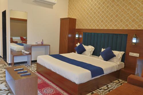 a bedroom with a large bed with a blue headboard at VITS Select Diamond Resort Sasan Gir in Talala