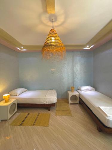 a room with two beds and a chandelier at Papaya Hostel in Agadir