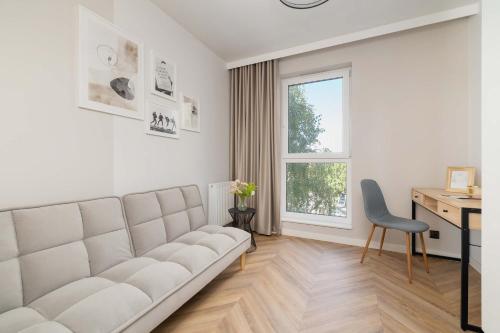 ティヒにあるAir Conditioned Apartment in Tychy with Parking and Desk by Noclegi Rentersのリビングルーム(ソファ、デスク、窓付)