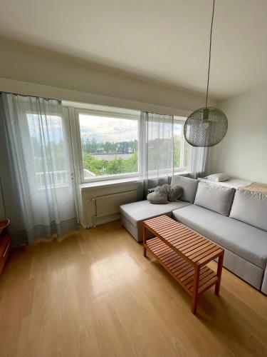 a living room with a white couch and a large window at Hotelli Aatto&Elli in Joutsa