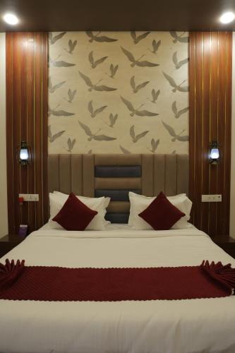a bedroom with a large bed with red pillows at VITS Select Diamond Resort Sasan Gir in Talala