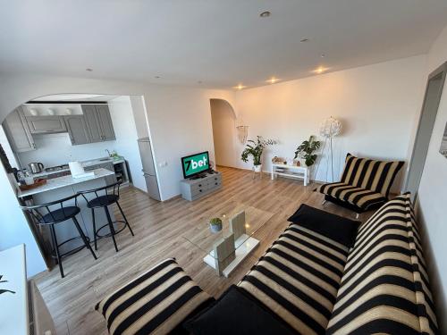 an open living room with a couch and a kitchen at Klaipėda Old Town Stay in Klaipėda