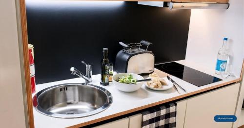 a kitchen counter with a sink and a toaster at smartments Bielefeld Hauptbahnhof in Bielefeld