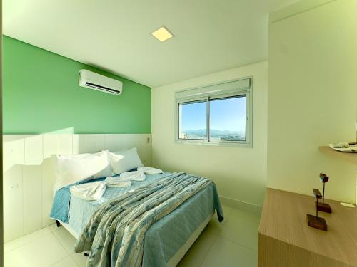 a bedroom with a bed and a window at Apto 3 Quartos Condomínio Resort Completo Pé na areia com Piscina borda Infinita, Beach Tennis, Academia, Sala de Jogos, Brinquedoteca, Playground e Portaria 24H 2 Quartos com Ar-Condicionado, Churrasqueira Privativa Reserve Agora e Viva essa Experiência in Piçarras