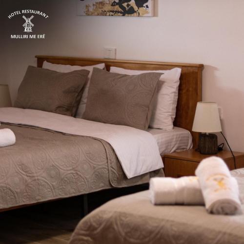 a bedroom with two beds and a table with a lamp at Hotel & Restaurant Mulliri me Erë in Rahovec