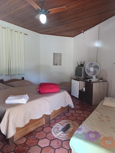 a room with two beds and a tv in it at Pousada Pé do Morro in Vale do Capao