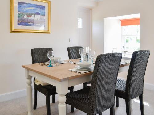 a dining room table with chairs and wine glasses at Grieve's Cottage - Uk11107 in Montrose