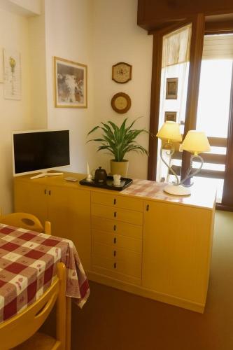 a bedroom with a yellow dresser with a tv on it at Artesina in Sella della Turra