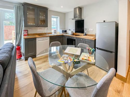 a kitchen with a glass table and chairs and a refrigerator at The Willows - Uk34000 in Child Okeford