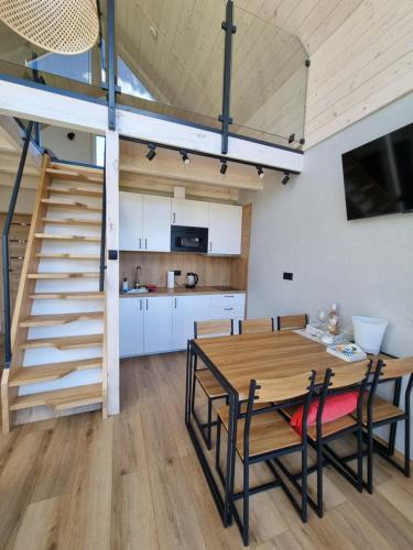 a kitchen and dining room with a wooden table and chairs at Przystań Lubie in Linowo