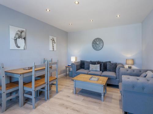 a living room with a couch and a table at Goose Green Cottage in Snettisham