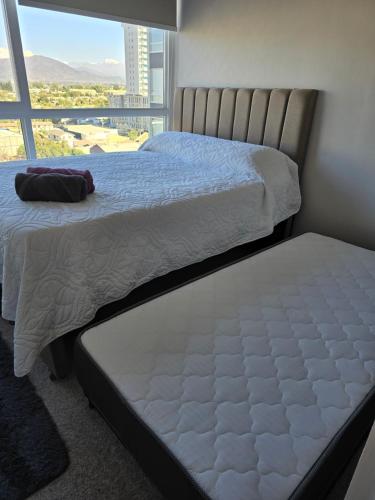 a bedroom with two beds and a large window at Nuevo departamento gran ubicacion central in Rancagua