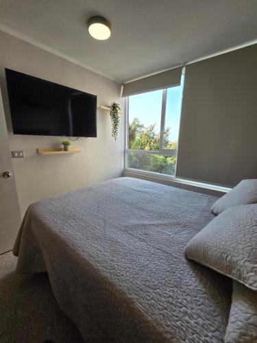 a bedroom with a bed and a large window at Nuevo departamento gran ubicacion central in Rancagua