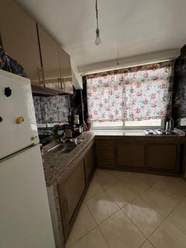 a kitchen with a refrigerator and a window at Appartement serein & apaisant in Bouznika