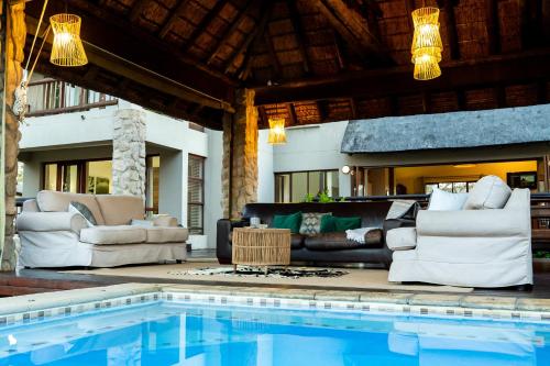 a living room with a couch and a swimming pool at 7th Hole Golf Lodge in Modimolle