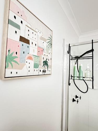 a painting hanging on a wall in a bathroom at Mi Casa Su Casa - 2BR Sleeps 6 - Free Parking - CBD in Brisbane