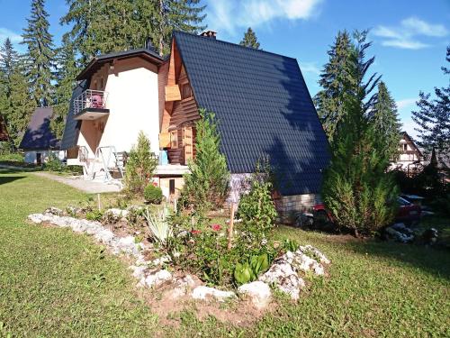 a log cabin with a garden in front of it at Vikendica Luna in Gornja Šišava