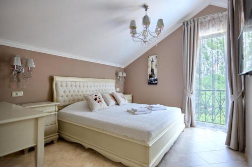a bedroom with a bed and a desk and a window at Boka Kotorska Apartmani in Gornji Orahovac