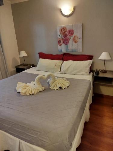 two swans are sitting on a bed in a bedroom at Hostal malvinas in Ushuaia
