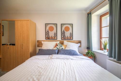 a bedroom with a large white bed with blue pillows at Gemütliches Studio in Altstadt - mit Sofa und Kochgelegenheit in Freiberg