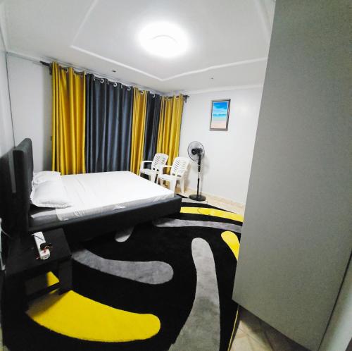 a room with a bed and a table and chairs at Zanzi Layover JKIA and SGR in Jomo Kenyatta Airport Nairobi