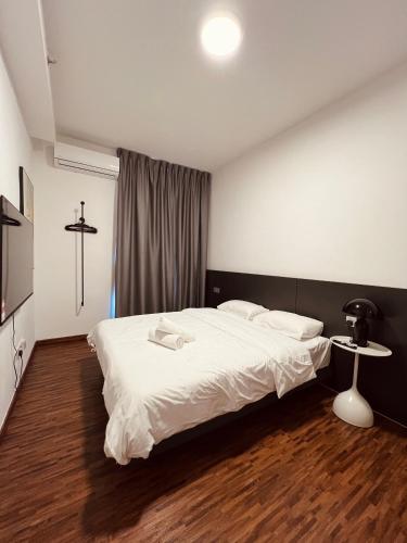 a bedroom with a white bed and a table at K-Avenue by FFix-Stay in Donggongon