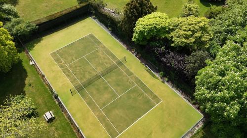 an overhead view of a tennis court at Unique & Rural Child Friendly Annexe with Large Gardens, Games & Tennis Court - Chichester Holiday Properties in Chichester