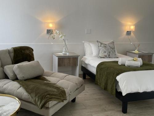 a living room with a couch and a bed and a chair at The Amaryllis Guest House in Mariental