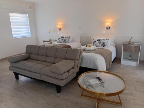 a living room with a couch and a bed at The Amaryllis Guest House in Mariental