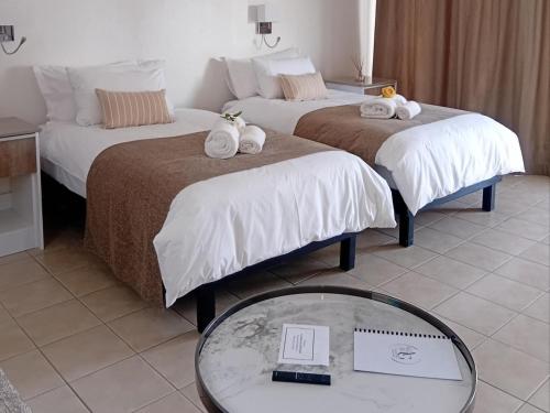 a hotel room with two beds with towels on them at The Amaryllis Guest House in Mariental