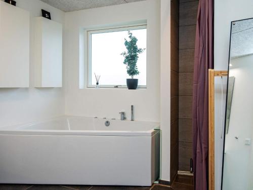a bath tub in a bathroom with a window at 14 person holiday home in Glesborg in Glesborg