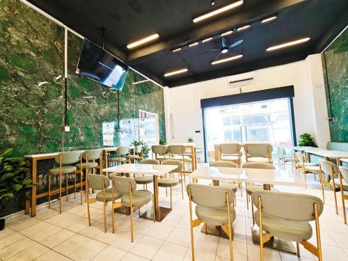 un restaurant avec des tables et des chaises et une grande fenêtre dans l'établissement Hotel Ma'Wa By Salaam Suites, à Kota Bharu