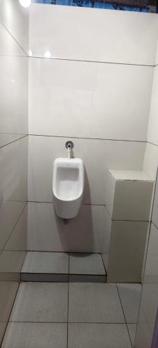 a bathroom with a urinal on a wall at V R S Luxury AC Male Dormitory in Mysore