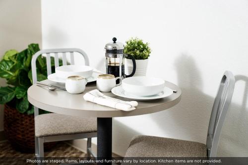a small white table with plates and cups on it at InTown Suites Extended Stay Salt Lake City UT - Midvale in Midvale