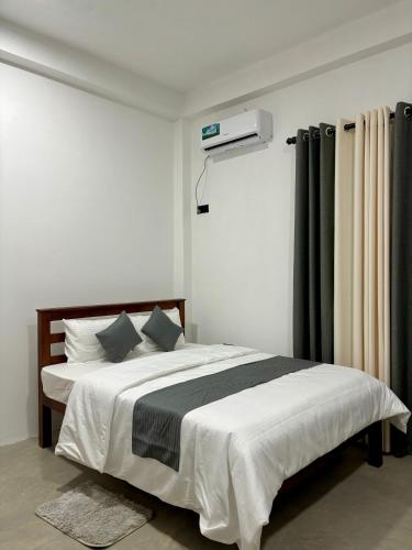 a bedroom with a large white bed with aigil at Riverston Water Front Villa in Rattota