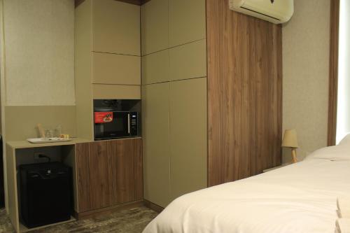 a hotel room with a bed and a microwave at Azmal Hotel & Suites in Irbid