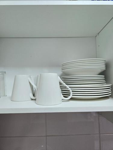 a white shelf with plates and bowls on it at Precioso central departamento in Rancagua