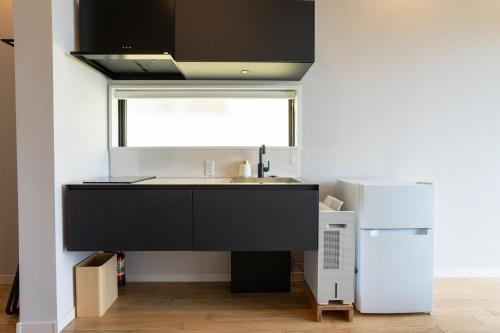 a kitchen with a sink and a refrigerator at TIMeSCAPE -tancha- in Onna