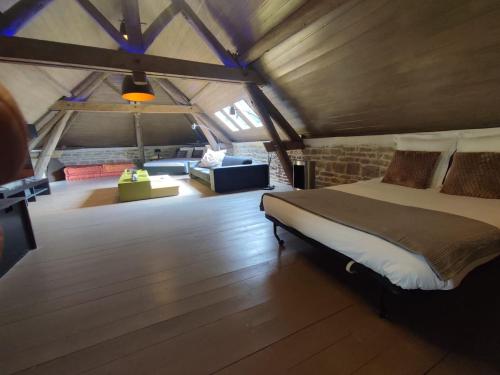 a bedroom with a bed and a couch in a room at Pommard Clos in Pommard