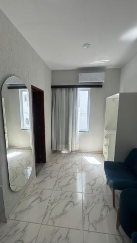 a living room with a mirror and a blue couch at Hotel Americas in Fortaleza