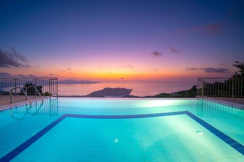 a swimming pool with a sunset in the background at Kamini by Vintage Travel in Dhefaranáta