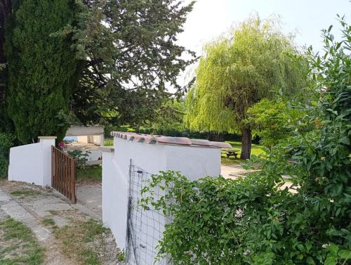 a white fence in a yard with trees at Villa Bel Air in Saint-Étienne-les-Orgues