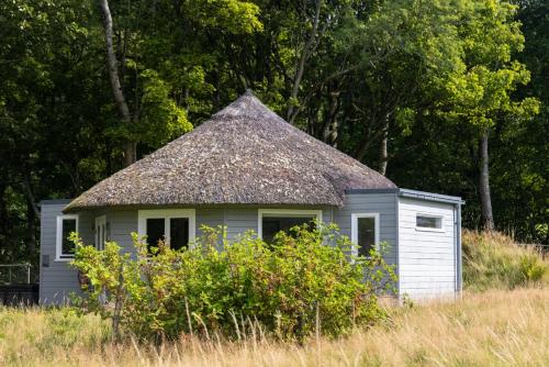 a small white house with a thatch roof at Ardeonaig Hotel & Restaurant in Ardeonaig