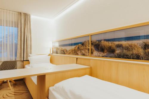 a small room with a bed and a desk at Parkhotel IV Jahreszeiten Kühlungsborn in Kühlungsborn
