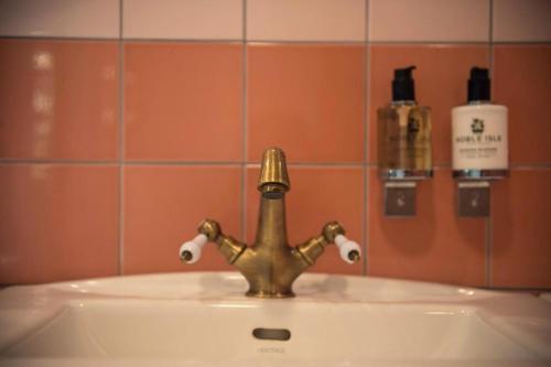 a bathroom sink with a brass faucet on it at Fox Hall in Richmond