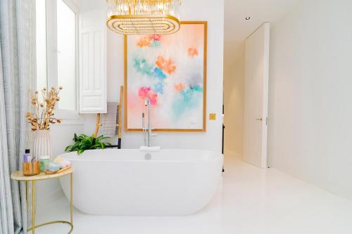 a bathroom with a tub and a painting on the wall at Luxury Golden Apartamento a solo pasos de Gran Vía in Madrid
